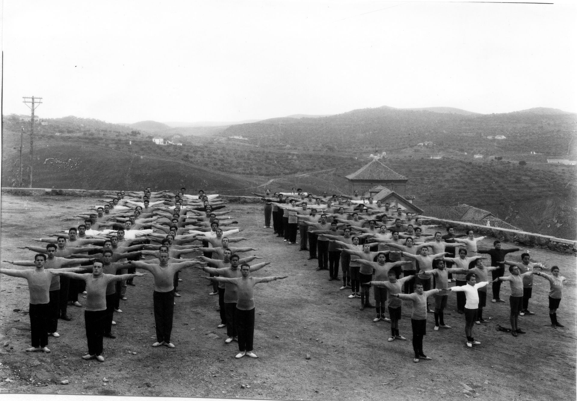 Clase de gimnasia, posiblemente de una academia preparatoria para el ingreso en la Academia, en el paseo de San Cristóbal hacia 1915. En este mismo lugar, en 1917, el Ayuntamiento cedió gratuitamente tres mil metros cuadrados para que la Guardia Civil construyese su cuartel. Otro proyecto fallido. (Archivo Histórico Provincial de Toledo)