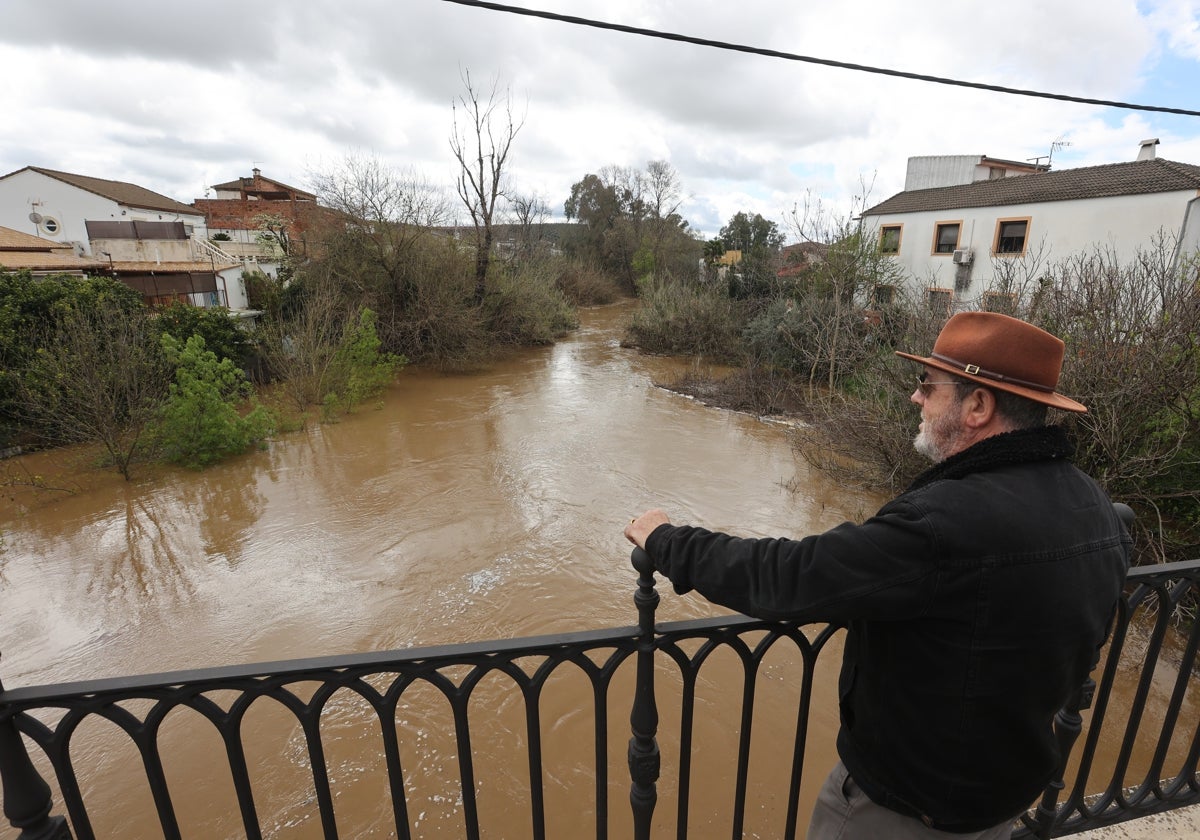 Tres vecinos observan el río a su paso por Alcolea