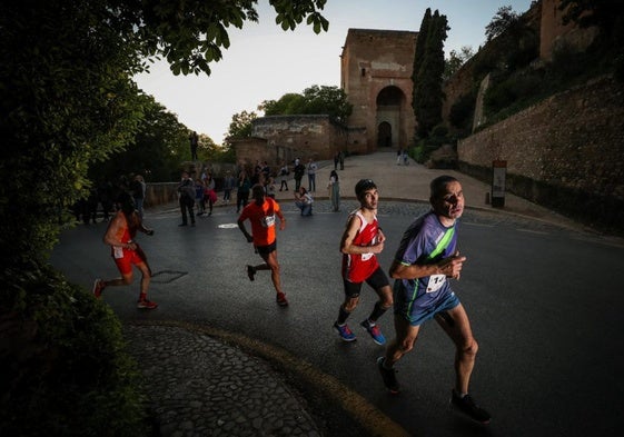 Corredores pasan junto a una de las entradas de la Alhambra en la edición de 2024