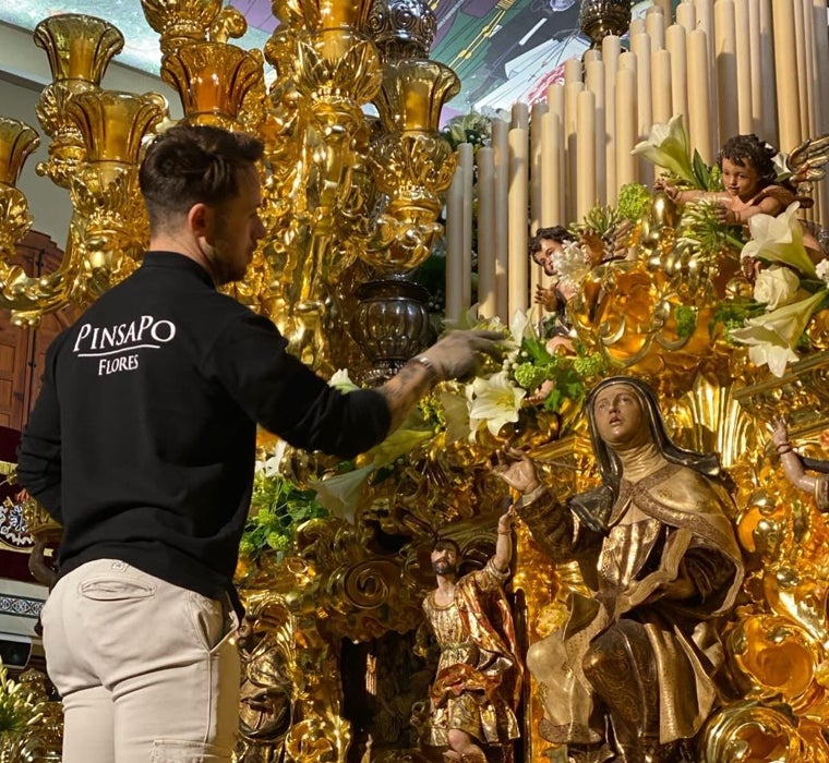 Luis Nevado ultima el exorno floral en el trono de la Esperanza de Málaga, en imagen de archivo