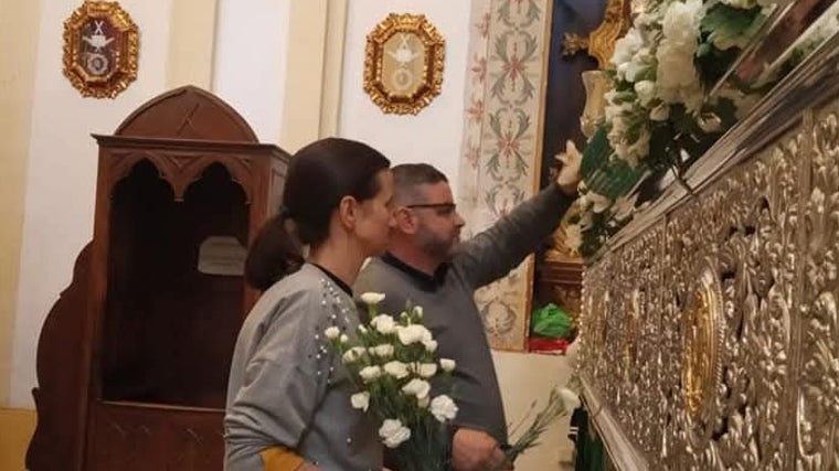 Bernabé Jiménez, a la derecha, dispone las flores en el palio de la Esperanza, junto con su ayudante