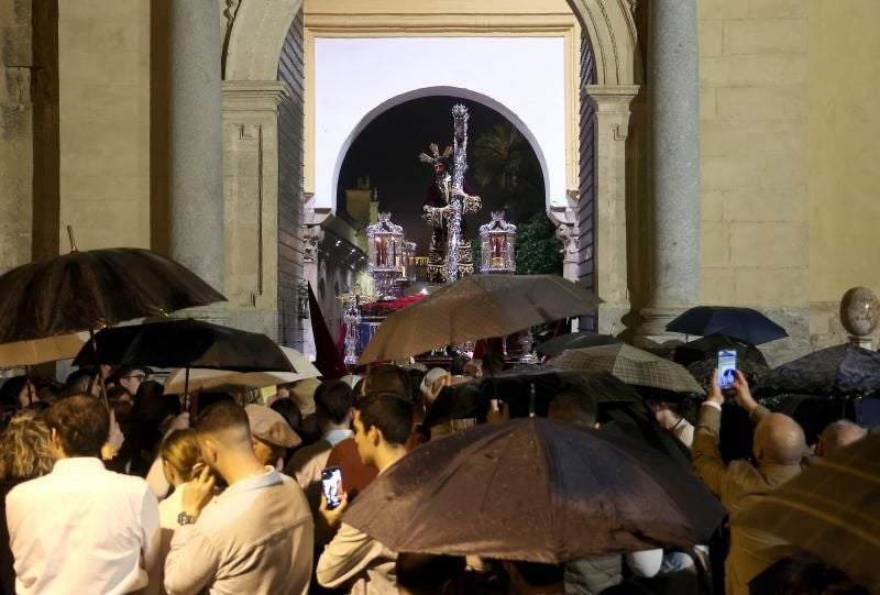 Cofrades y fieles aguardando bajo la lluvia la salida de una procesión