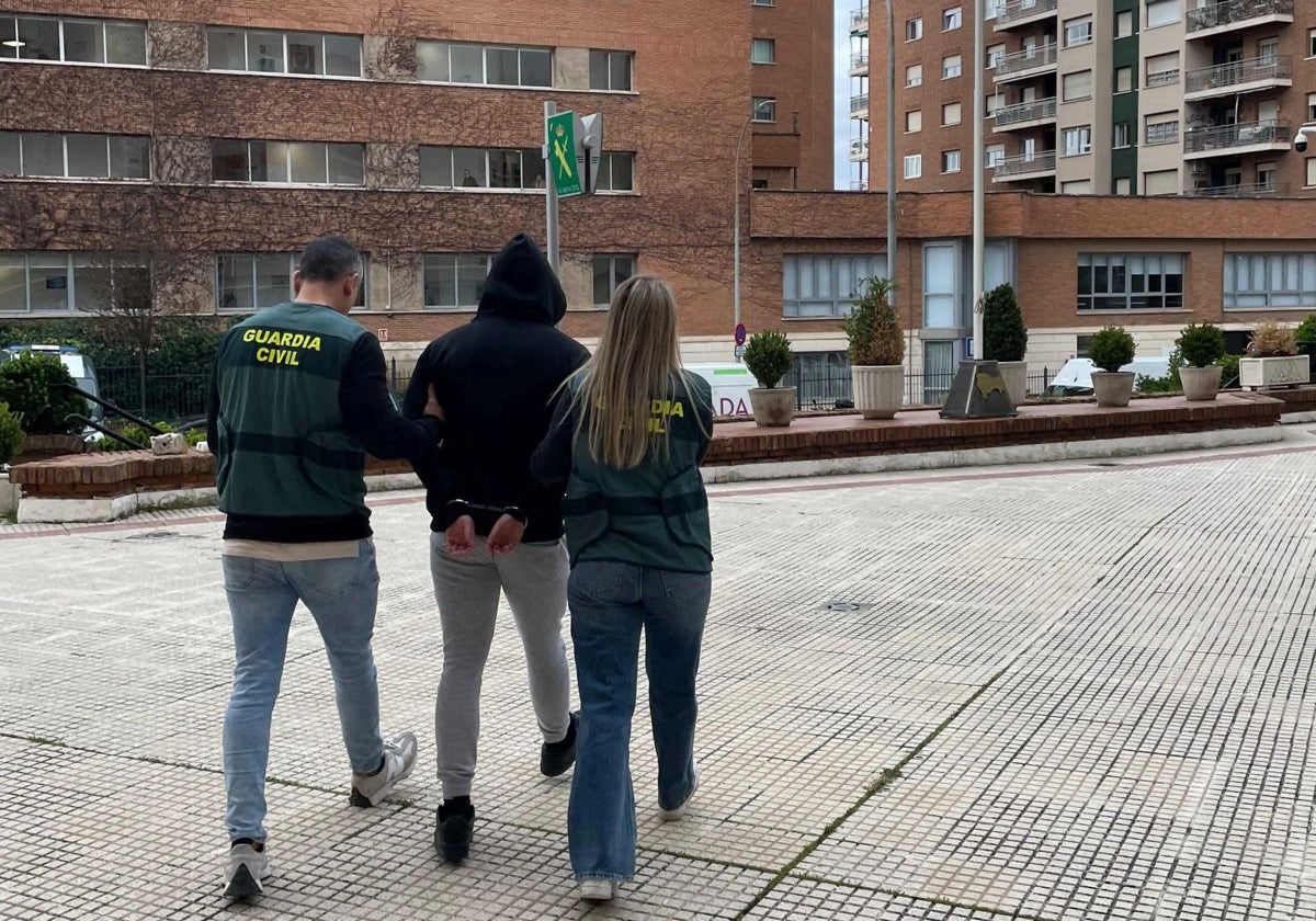 Dos agentes trasladan a uno de los detenidos
