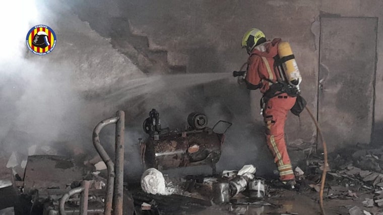 Un bombero trabaja en la extinción del incendio en una nave industrial de Picassent