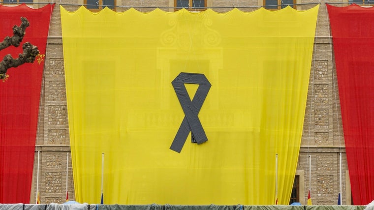 La gran bandera de Aragón colocada en la fachada de la sede del Gobierno autonómico con motivo de la festividad de San Jorge, patrón de la comunidad, luce un crespón negro en señal de duelo por el fallecimiento del Papa Francisco, este martes en Zaragoza