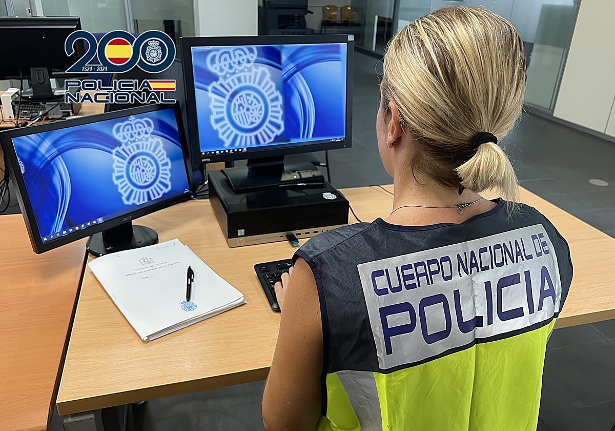 Una agente de la Policía Nacional delante de un ordenador