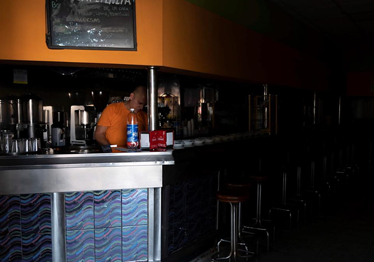 Un empleado de un bar de Tenerife intenta trabajar a oscuras durante el apagón de 2019