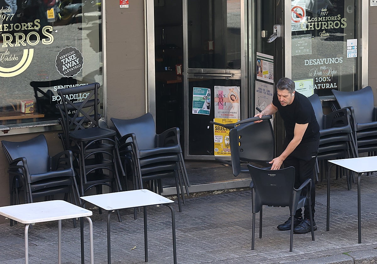El encargado de un bar en el centro de Córdoba coloca las mesas y sillas de la terraza este martes