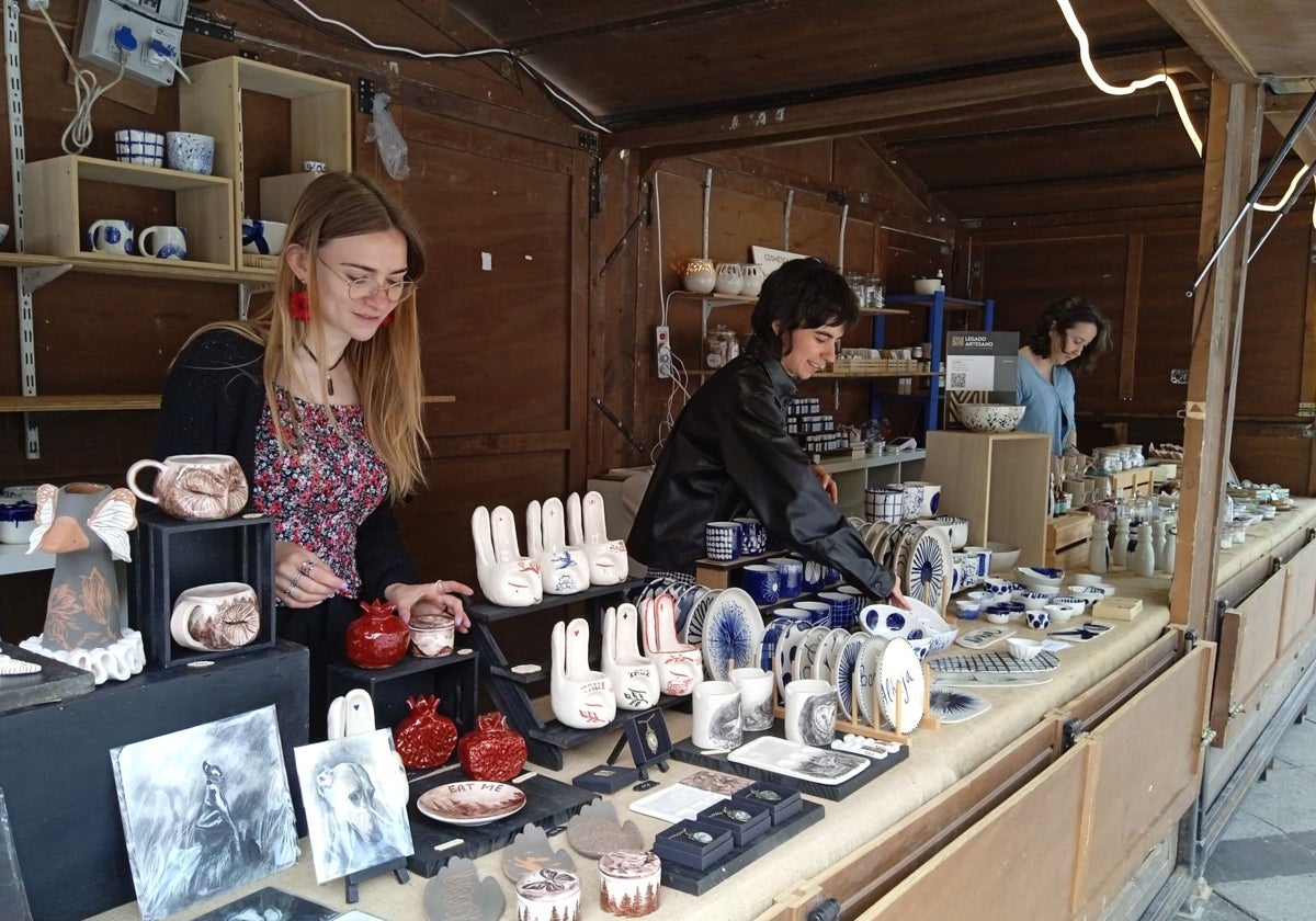 María Camisón (centro) colocando algunos de los objetos artesanos que se exhiben en la feria MATRIA