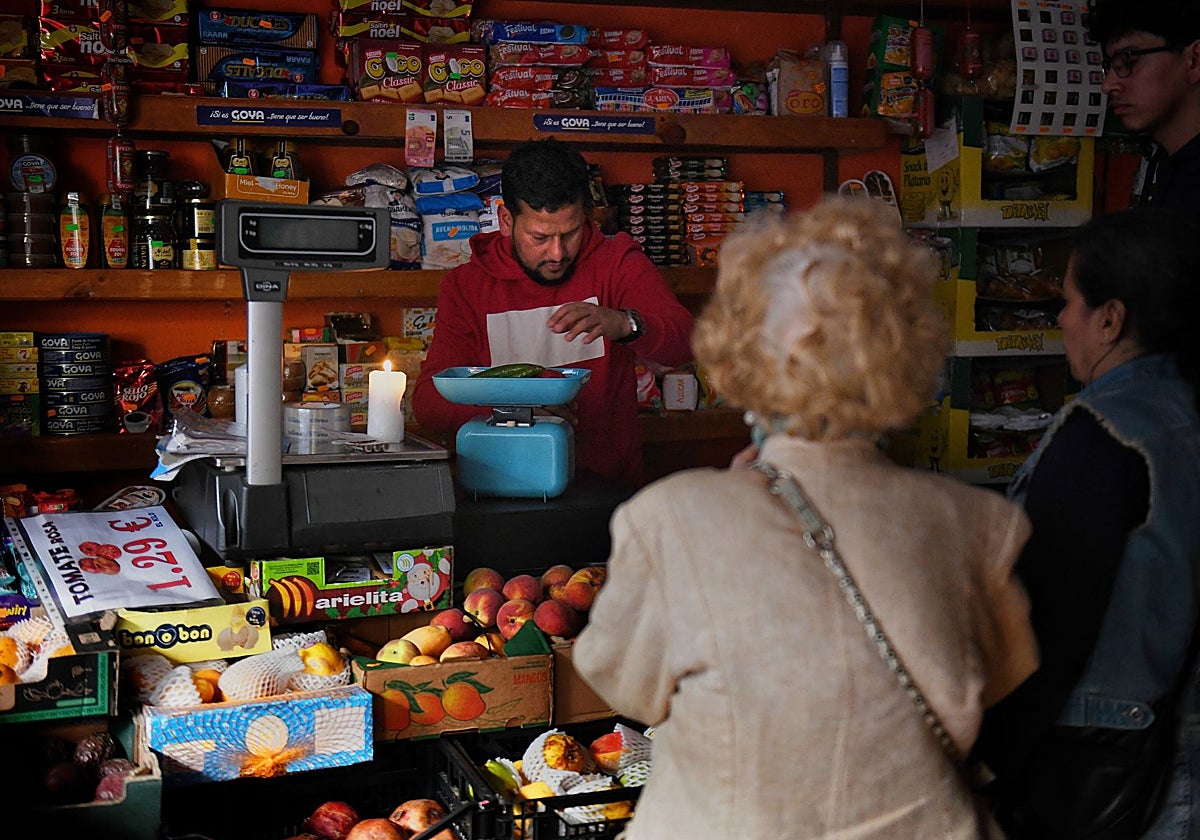 Un comerciante atiende, con velas y una báscula mecánica, su comercio en Madrid