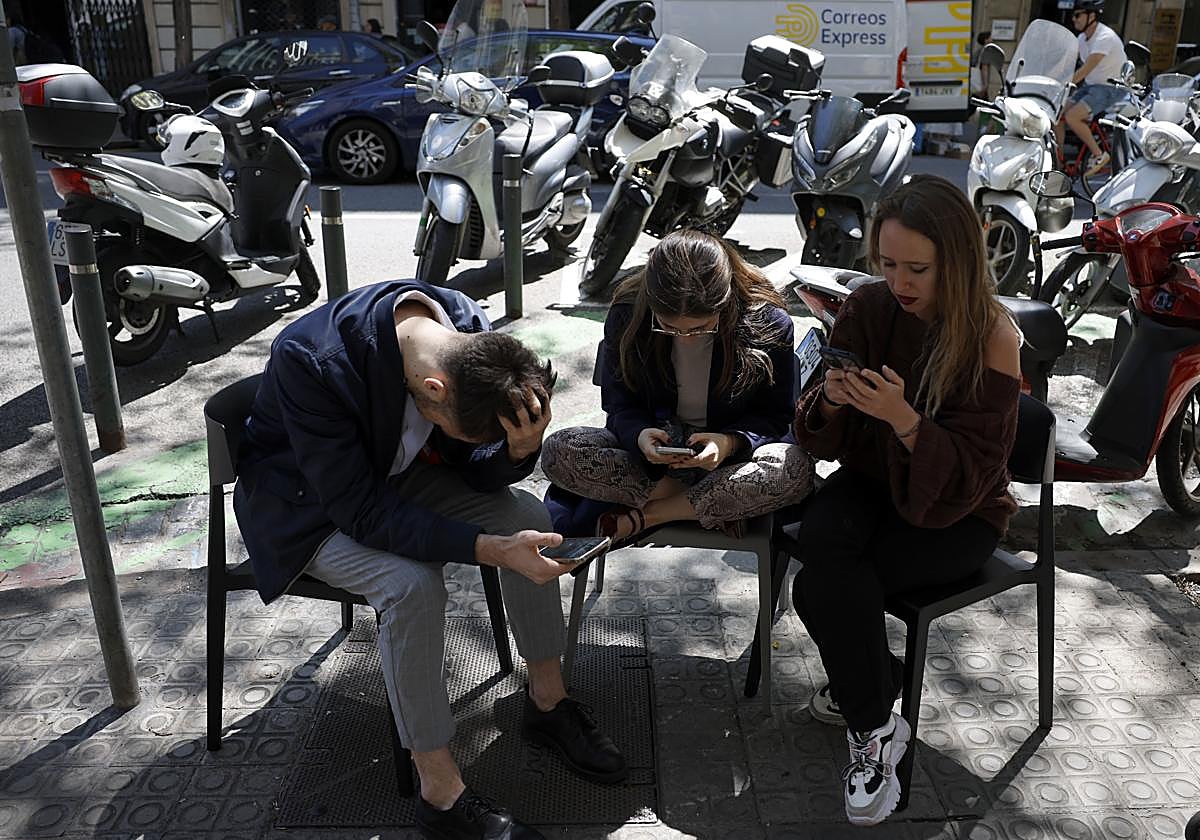 Jóvenes miran el teléfono el día del apagón eléctrico en España
