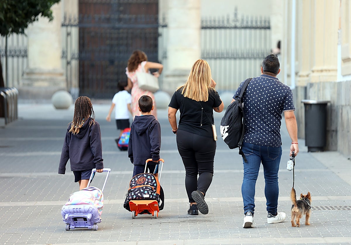 Unos padres acompañan a sus hijos el primer día de este curso a clase en el Centro de Córdoba