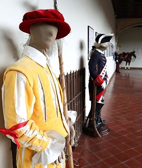 Imagen secundaria 2 - En la imagen superior, algunos de los visitantes que han recorrido esta muestra. En las imágenes inferiores, el caballo vestido con las galas de la sección de Coraceros del escuadrón de la escolta real. A la derecha, trajes históricos de este cuerpo militar