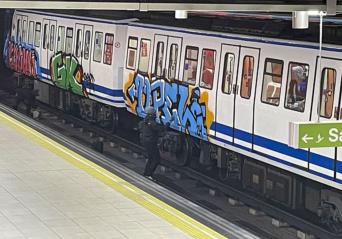 Un grupo de jóvenes, pintando grafitis en el Metro de Madrid