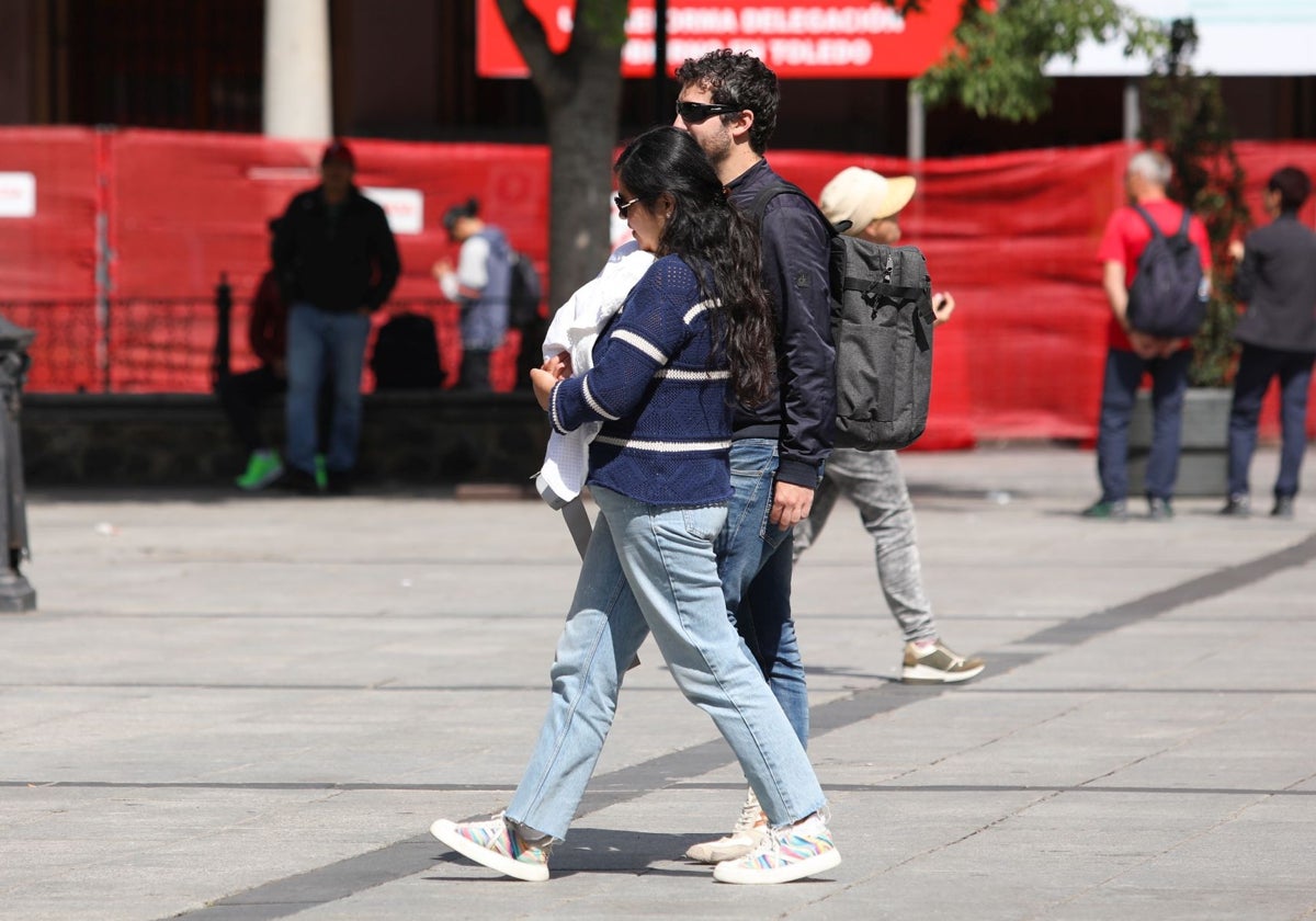 Una pareja pasea con su bebé por la plaza de Zocodover