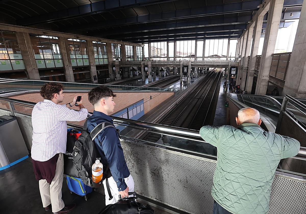 Unos pasajeros observan las vías vacías de la estación durante la caótica jornada del lunes