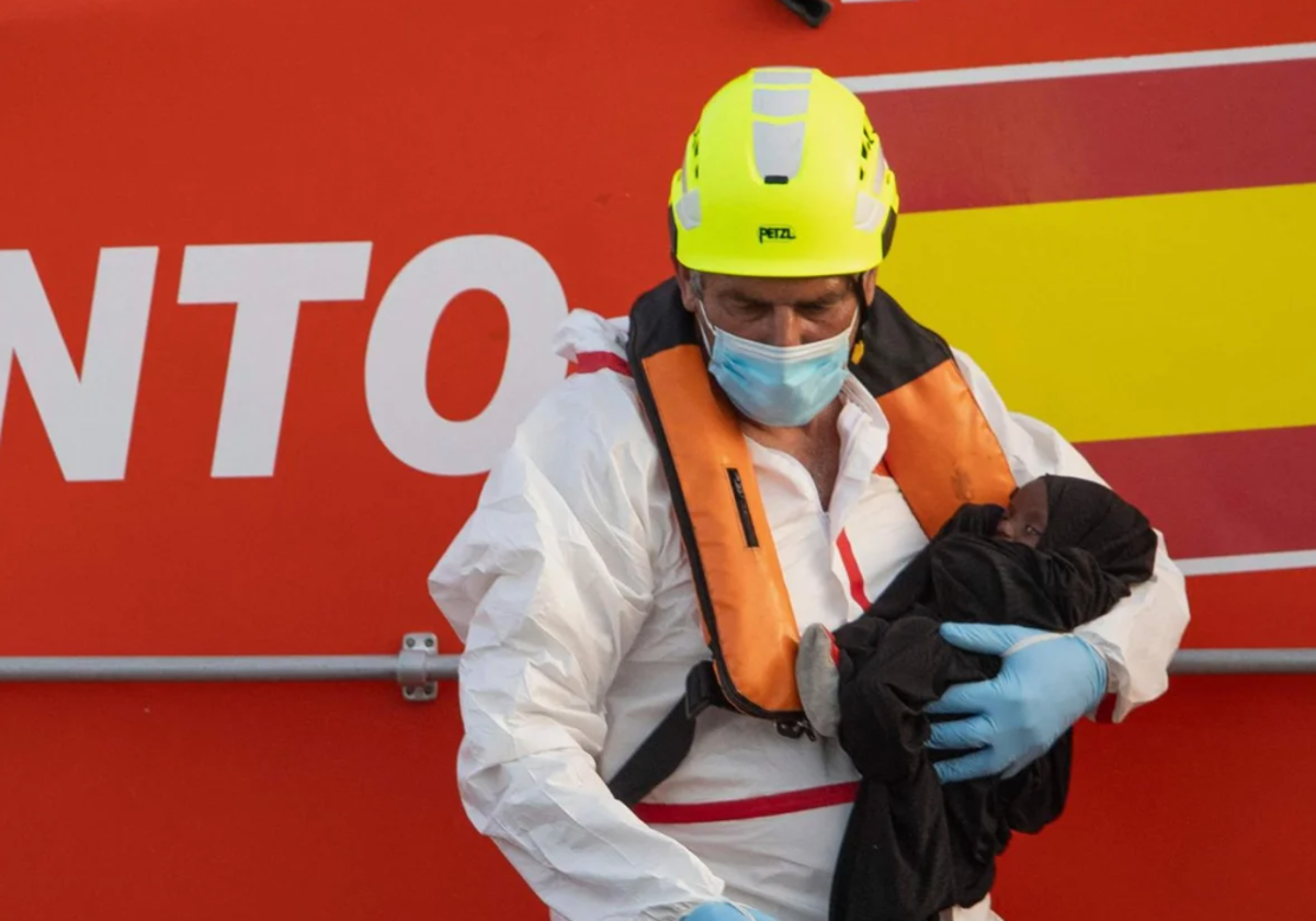 Un rescatador sostiene en brazos a un bebé recién rescatado de un cayuco con 136 migrantes y 17 menores en foto de archivo en noviembre de 2024
