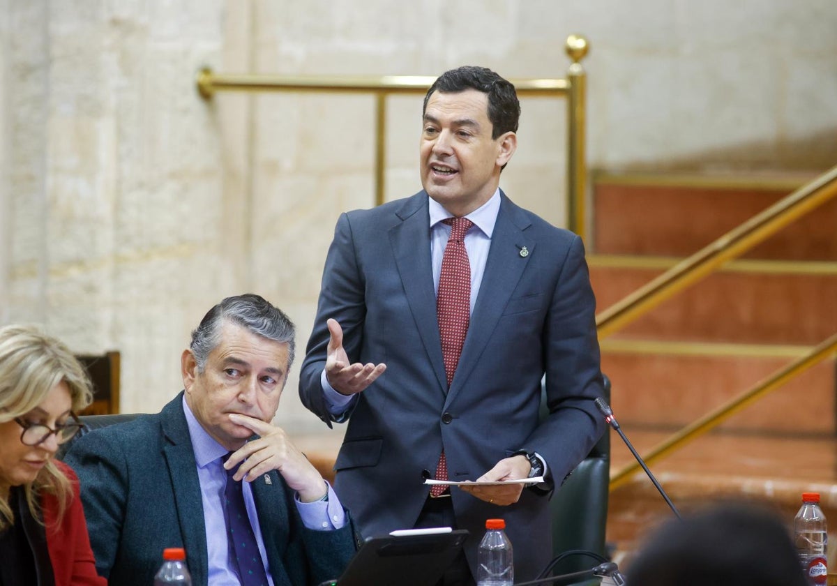 El presidente de la Junta de Andalucía, Juanma Moreno (de pie). Al lado, los consejeros Carolina España y Antonio Sanz