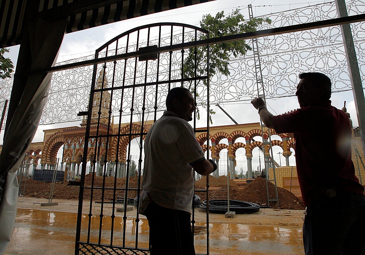 Dos operarios colocan una puerta en una carpa