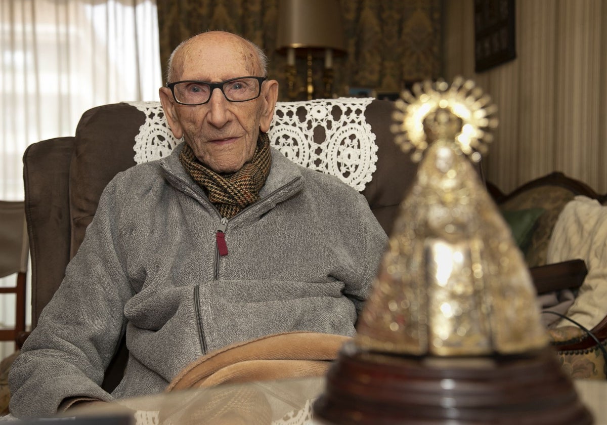 José Escobar, con una reproducción de la Virgen de los Dolores, en su casa en enero de 2024