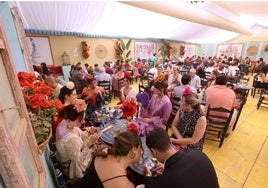 Grupos de familias almuerzan en una caseta de la Feria de Córdoba