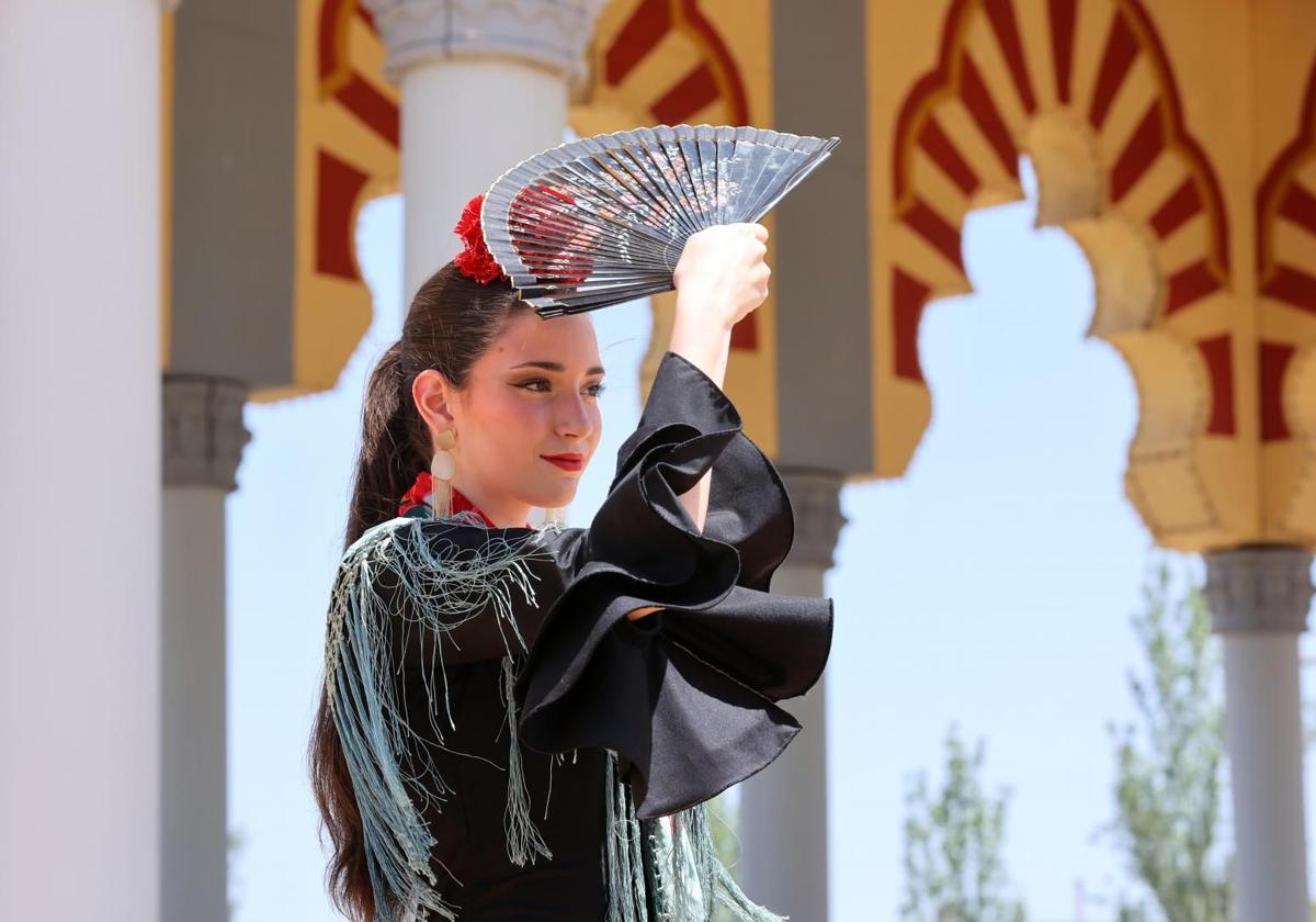 Una joven se protege del sol con un abanico en la pasada edición de la Feria de Córdoba