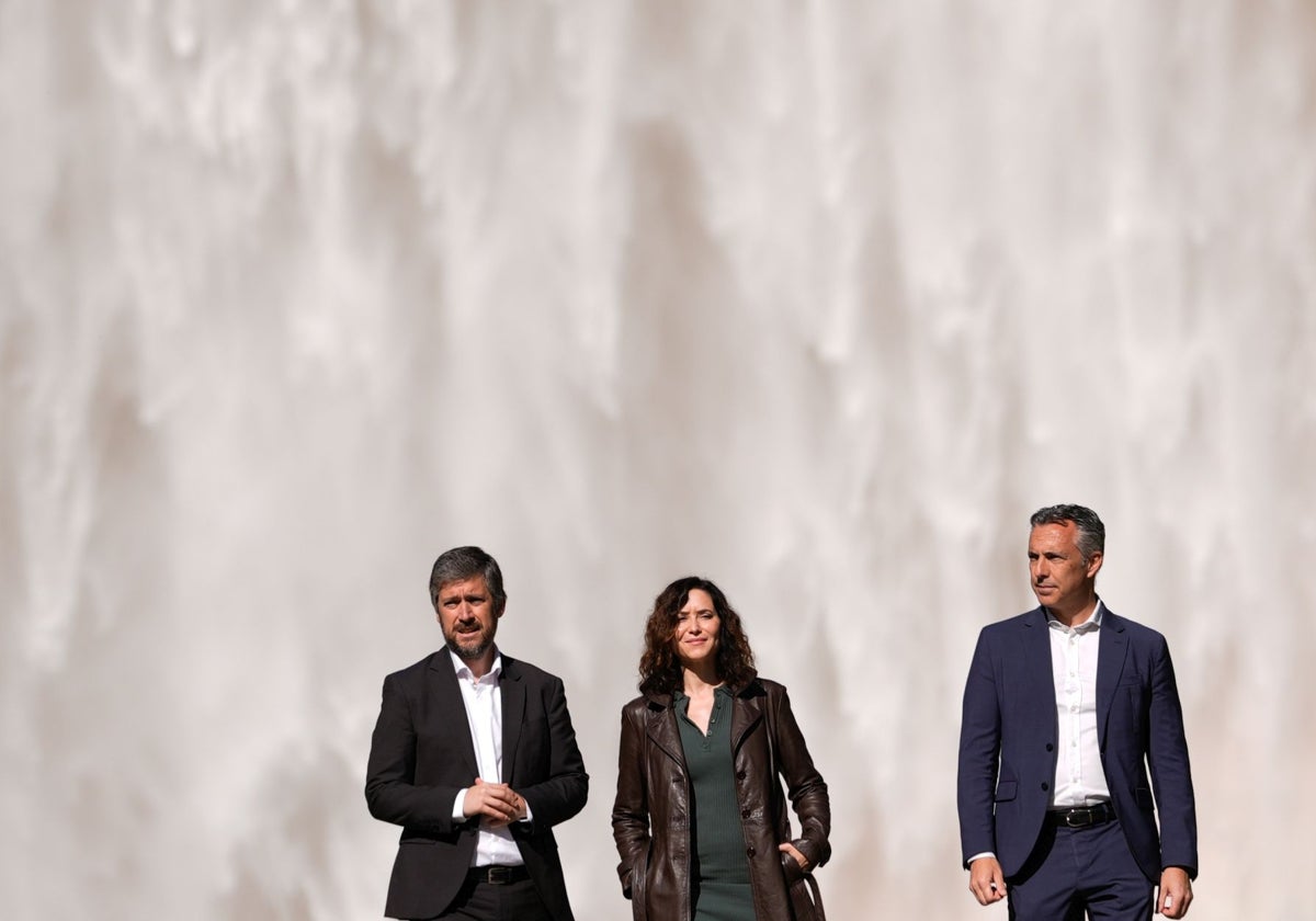 Díaz Ayuso, entre sus consejeros de Presidencia (izq.) y Medio Ambiente, bajo la presa de El Atazar, que desembalsa agua desde hace unos días