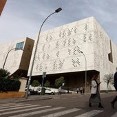 Una pareja cruza por el paso de peatones próximo a la Ciudad de la Justicia