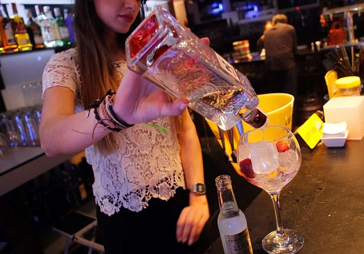 Una camarera sirve una copa en un bar de Valencia en foto de archivo