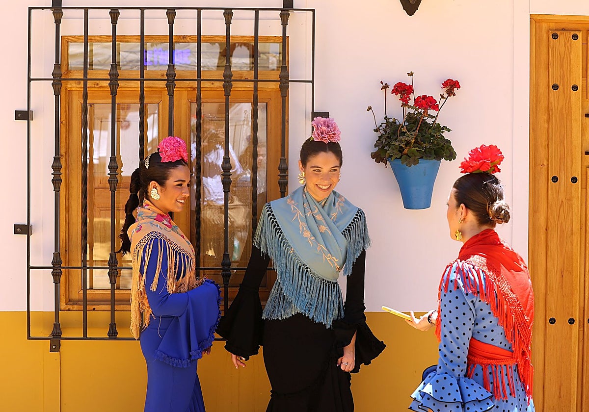 Tres jóvenes junto a una caseta de la Feria de Córdoba