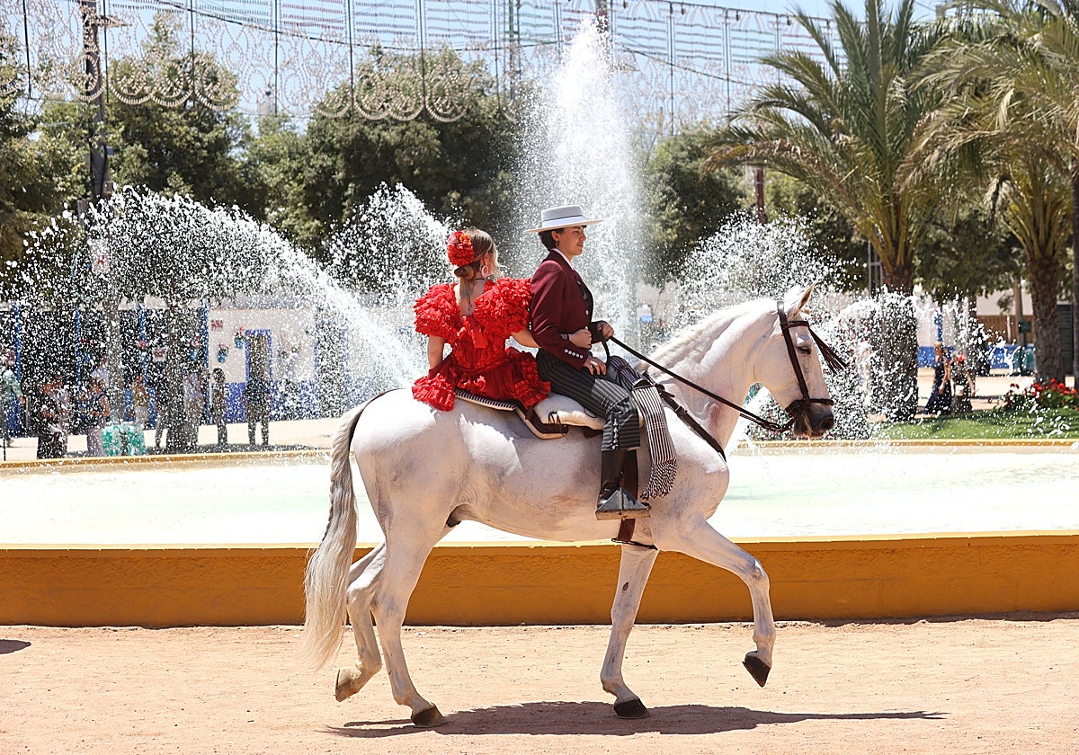 Un caballista pasea por los accesos de la portada de la Feria junto a la fuente principal