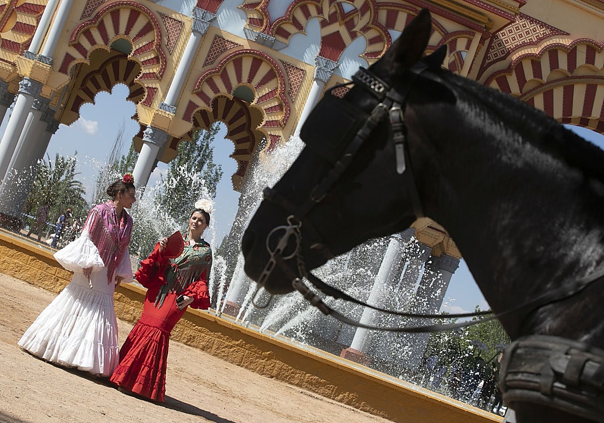 Dos mujeres junto a la portada de la Feria de Córdoba