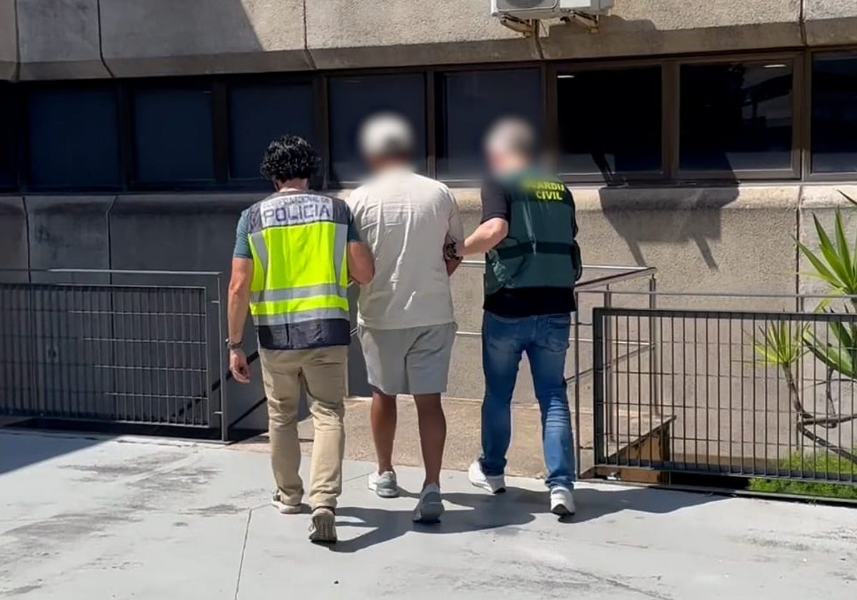 Agentes de la Guardia Civil y la Policía Nacional escoltan a un detenido a comisaría