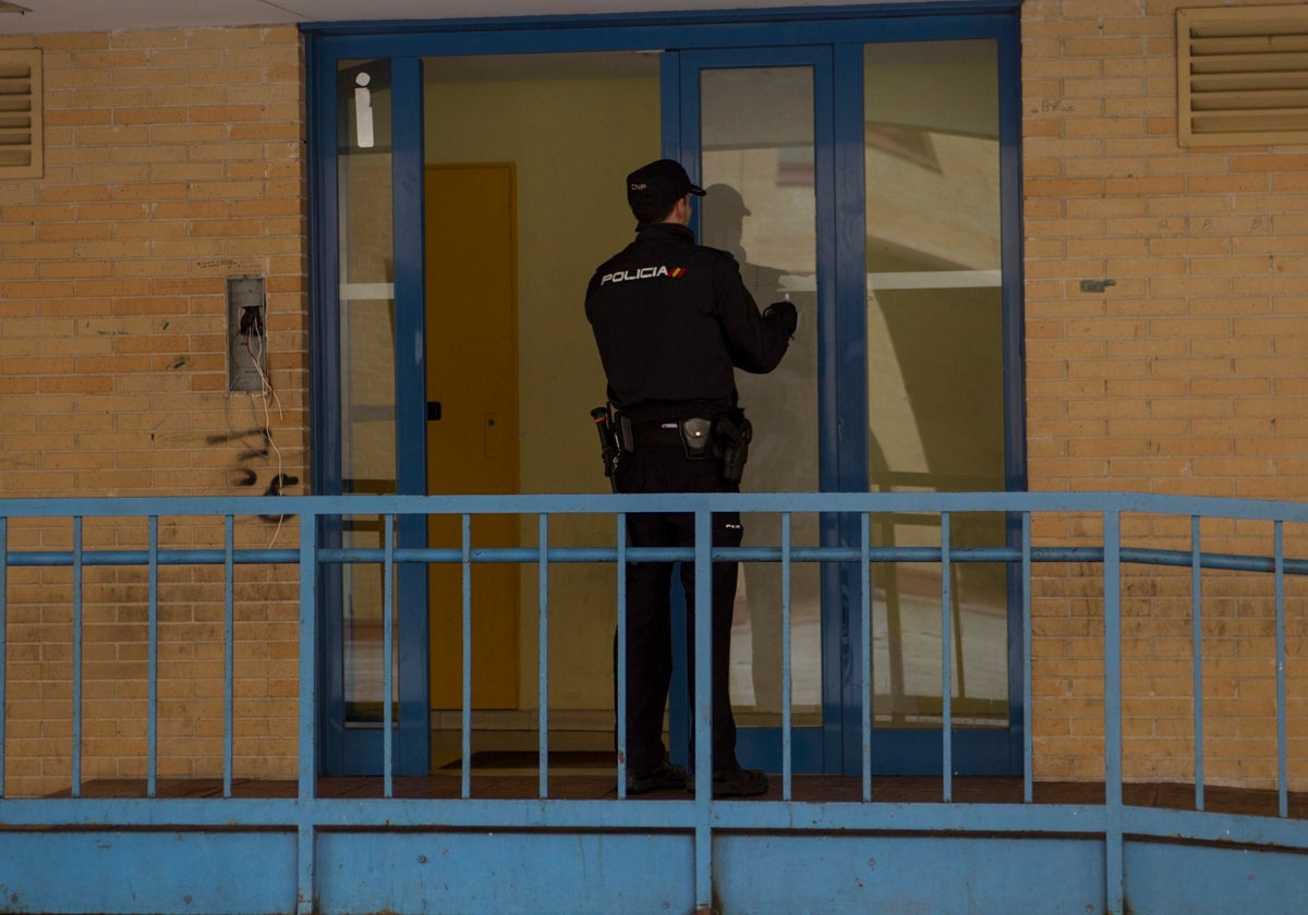 Un agente de Policía Nacional en la entrada de un edificio en Parla
