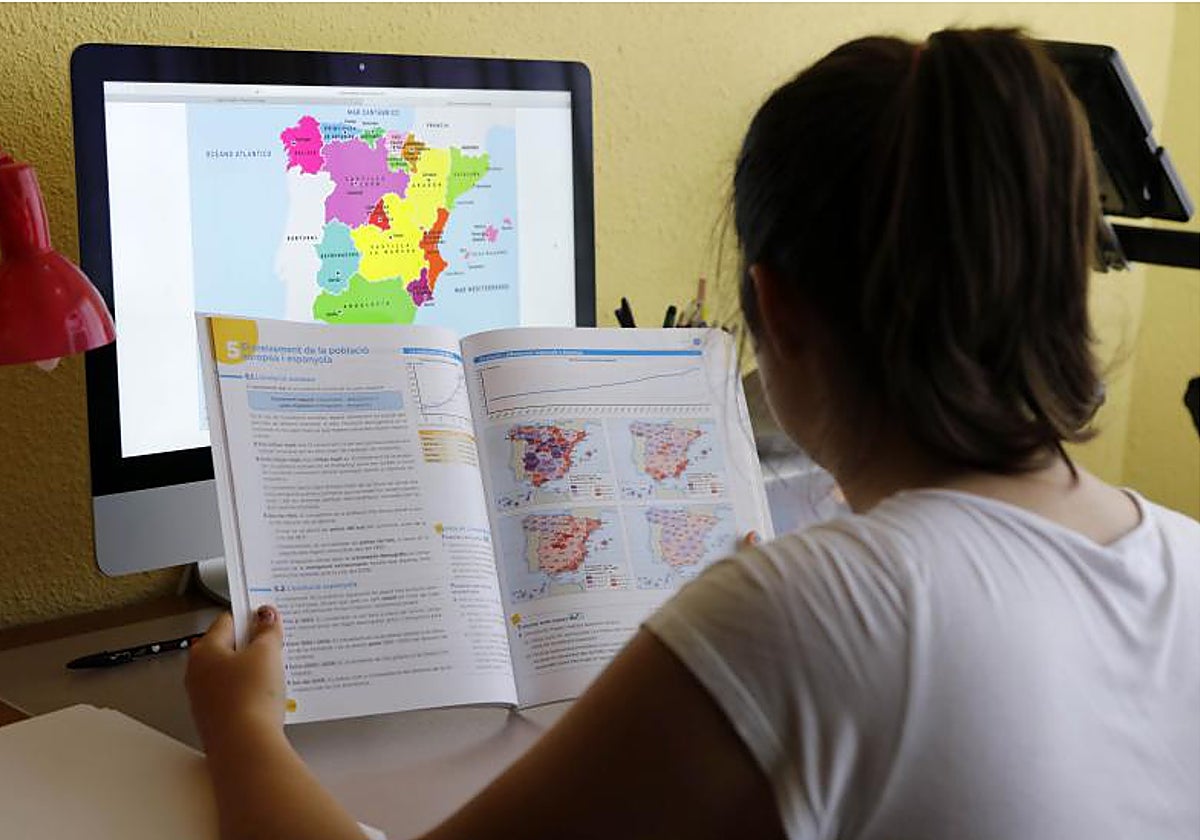 Una estudiante revisa un libro de texto en valenciano en Alicante