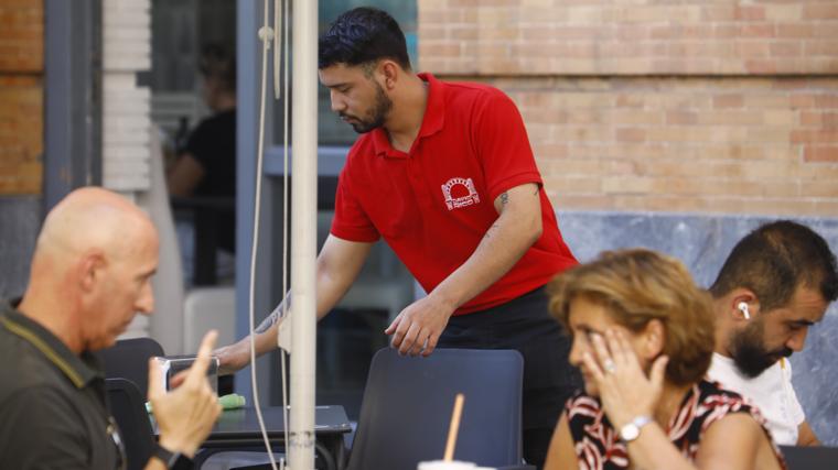 Un joven camarero atiende una terraza en el Centro