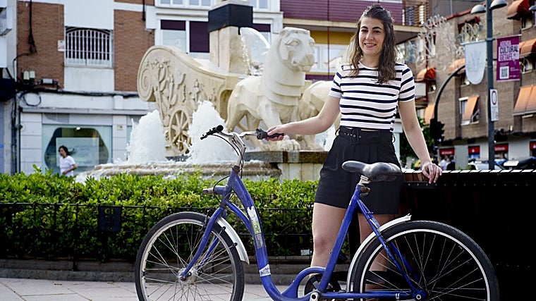 Silvia posa con su bicicleta recién conseguida frente a la fuente de la Cibelina