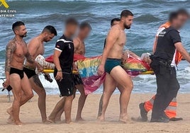 Imagen de los bañistas y agentes socorriendo a la víctima