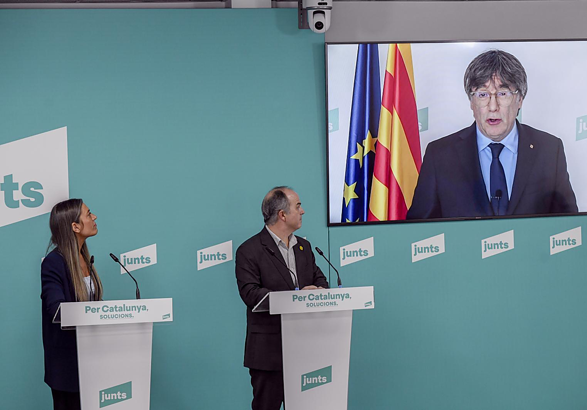 Míriam Nogueras, Jordi Turull y Carles Puigdemont (en una televisión), en la sede de Junts en Barcelona, durante una rueda de prensa en marzo de este año