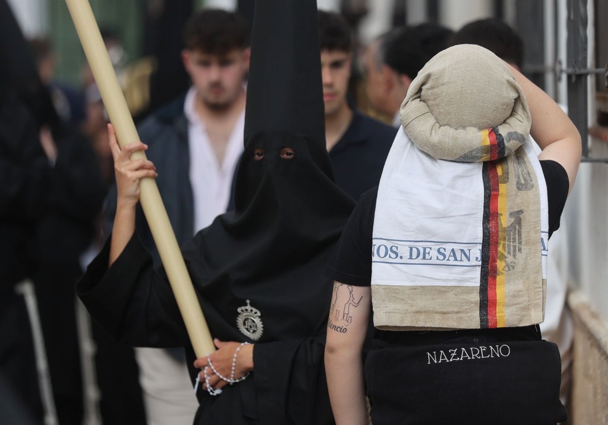 Un costalero junto a un nazareno en la Semana Santa de Córdoba