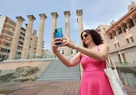 Una mujer saca una fotografía en el Templo Romano