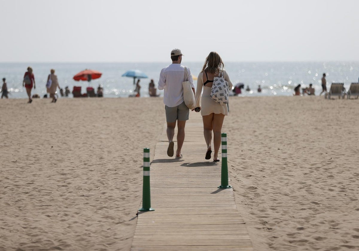 Dos personas pasean por la playa de la Malvarrosa de Valencia