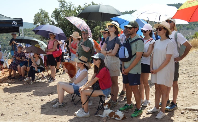 Imagen principal - Sobre estas líneas, los fieles se resguardan del sol con paraguas y sombreros en el cerro del Mogorro