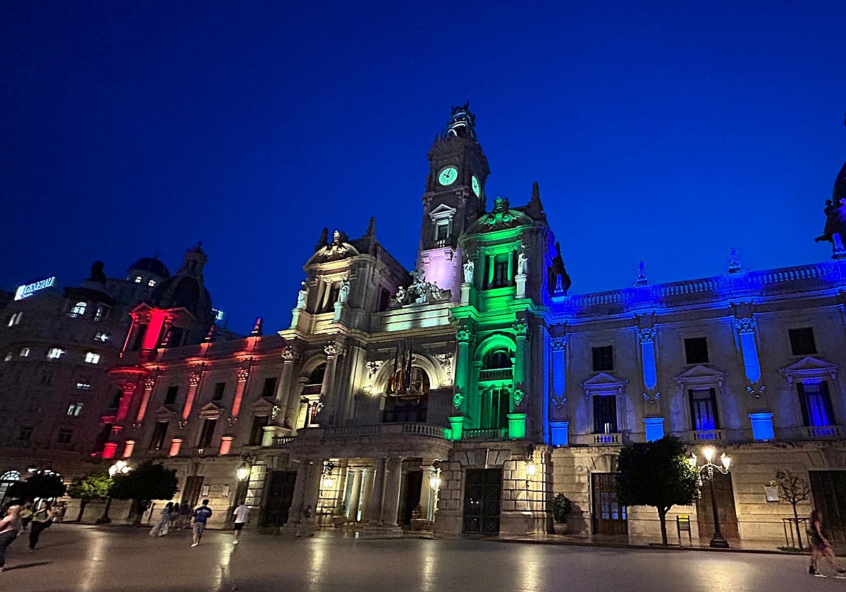 Imagen de la fachada del Ayuntamiento de Valencia iluminada con los colores de la bandera LGTBIQ+