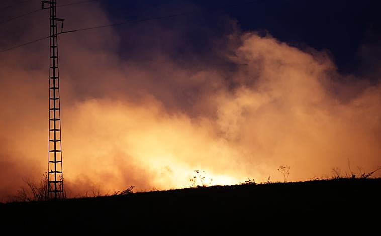 Imagen principal - Los efectivos del SEIS están haciendo frente a un incendio de envergagura en el complejo medioambiental de Sadeco (imagen superior). Los bomberos municipales están desplagados (imagen inferior izquierda) en una condiciones difíciles. de noche, con viento y en un clima muy seco. Las columnas de humo son visibles en la zona (imagen inferior derecha)