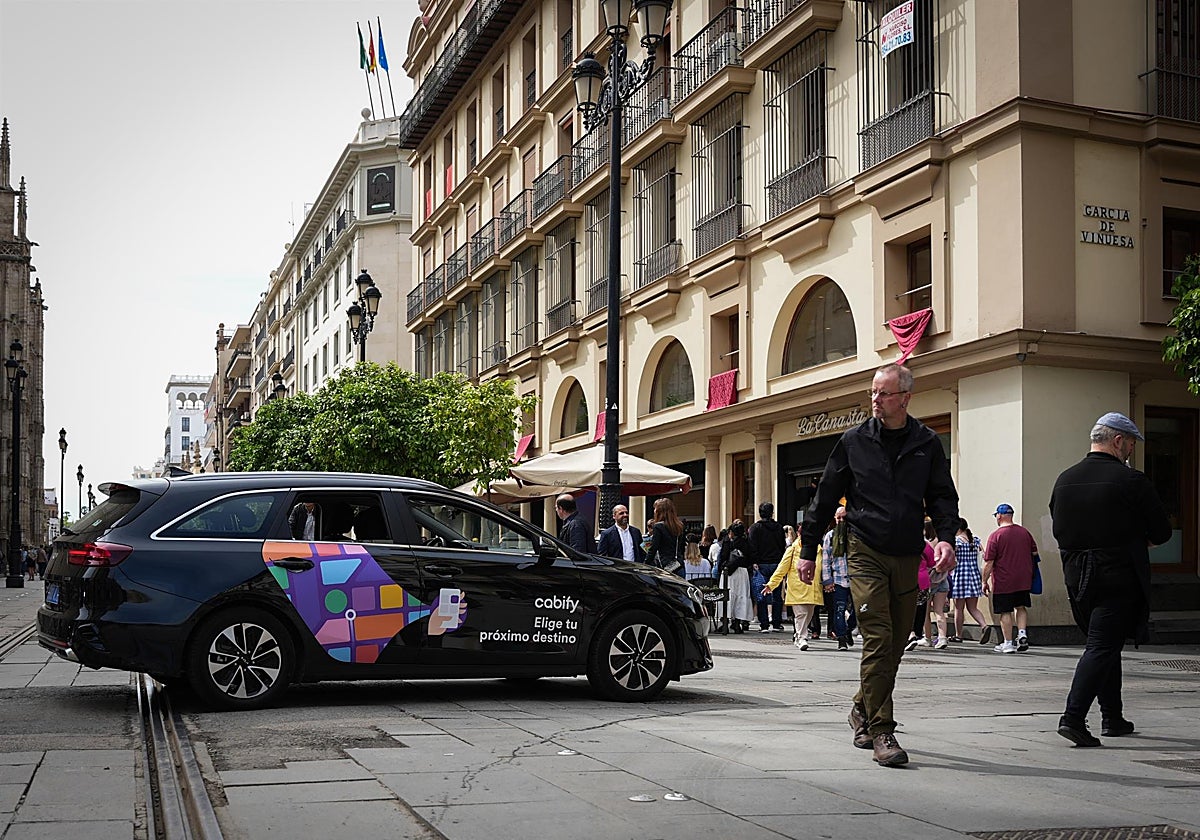 Un vehículo VTC circula por una calle del centro de Sevilla
