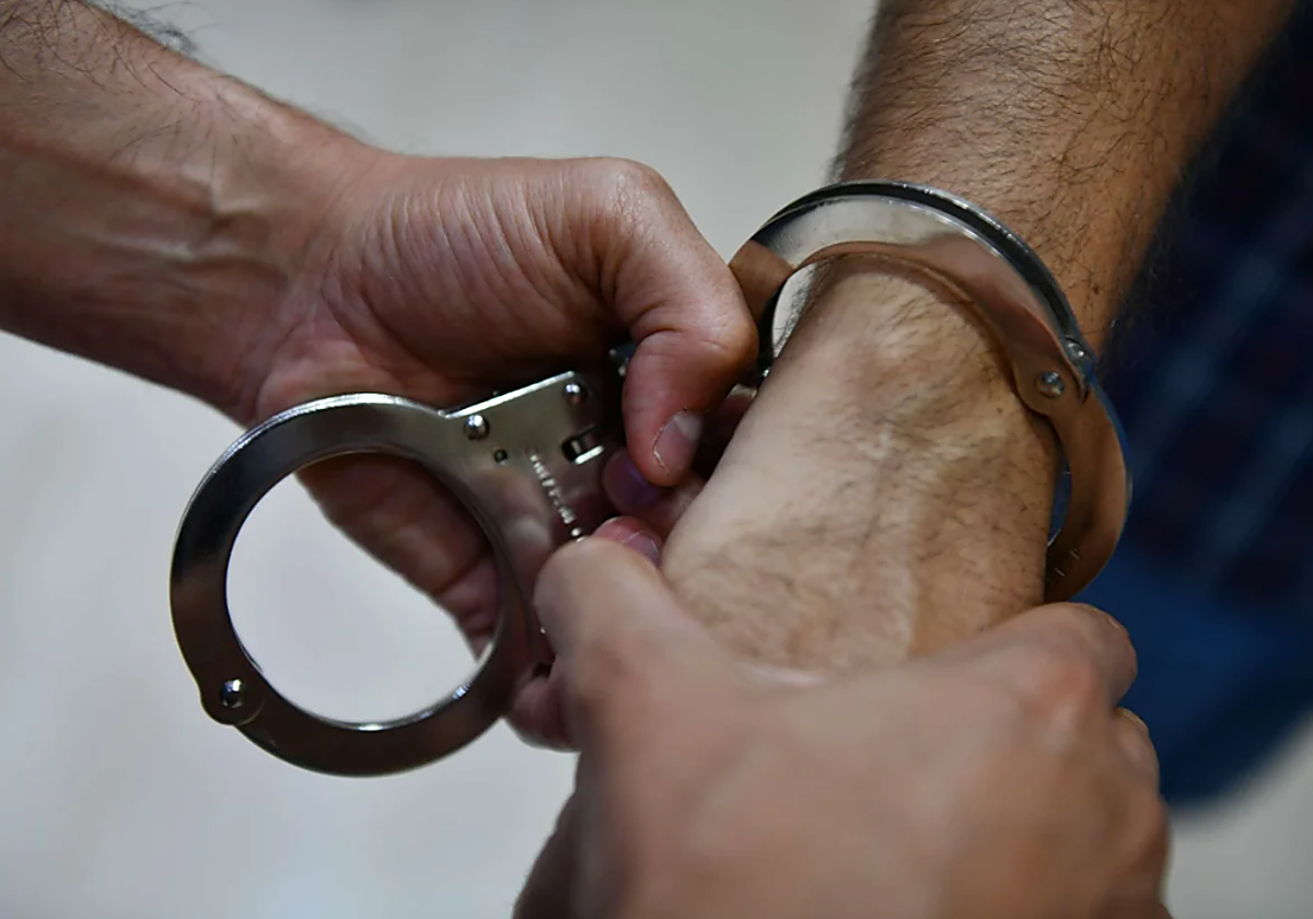 Un agente coloca las esposas a un detenido, en una imagen de archivo