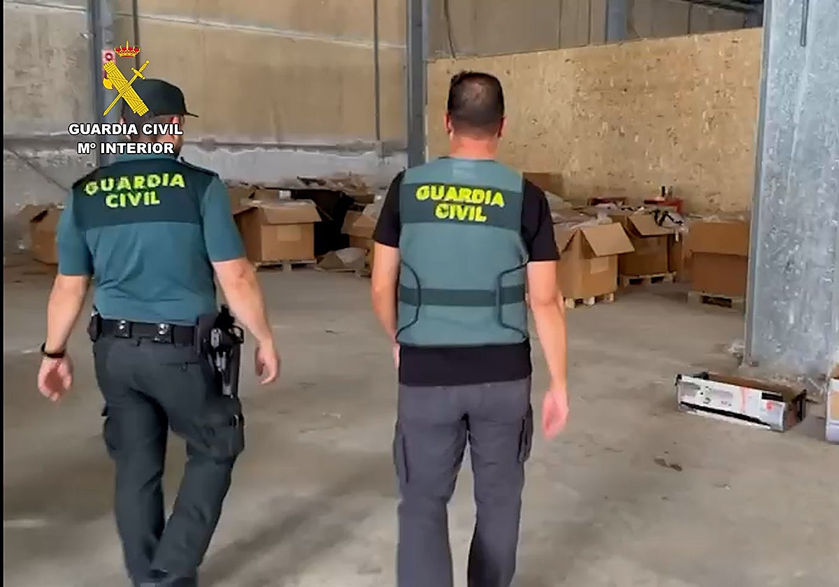 Dos agentes en la nave donde se ha localizado este centro de producción de picadura de tabaco
