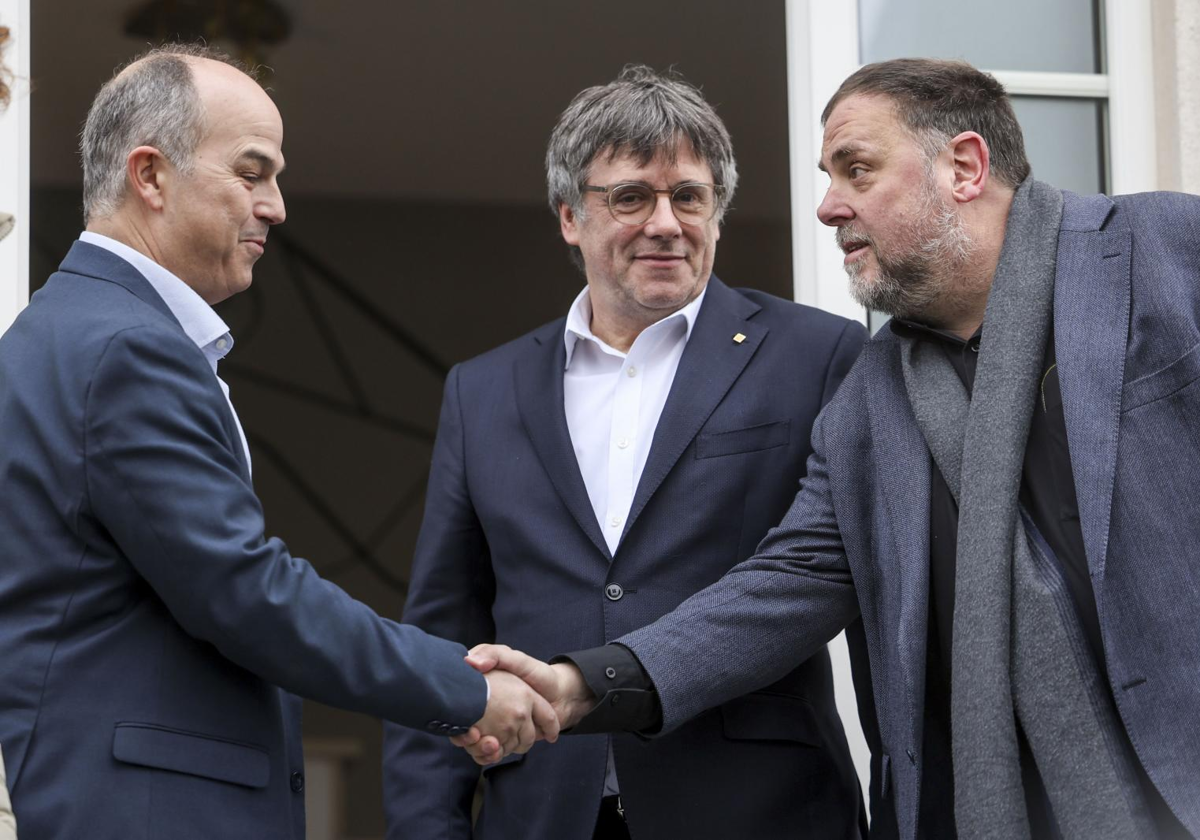 Jordi Turull y Oriol Junqueras se saludan, ante Carles Puigdemont, en Waterloo (Bélgica) antes de una reunión a inicios de este año