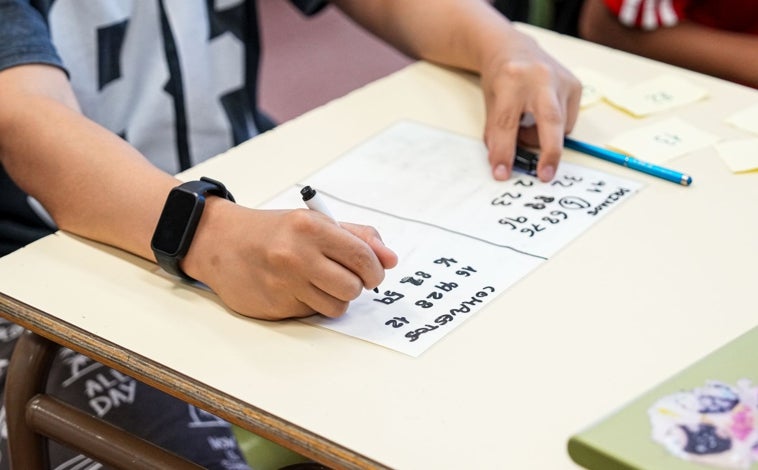 Imagen principal - Sobre estas líneas, un alumno completa un ejercicio de Matemáticas en el aula de refuerzo. Tatiana Rodrigues y Moisés Vera, dos participantes del programa